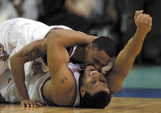 Juan Dixon tackles teammate Lonny Baxter after leading Maryland to victory on Monday night. (www.krtcampus.com)