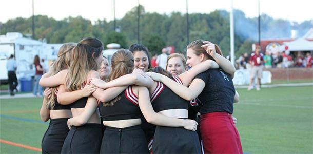 The cheerleading team gathers to prepare for another formation during the Homecoming game on Saturday, Sept. 19. 