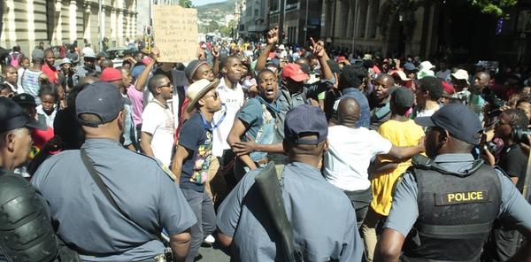 Police watch a student protest on Oct. 22, 2015. The students managed to convince President Jacob Zuma to suspend tuition increases for a year.