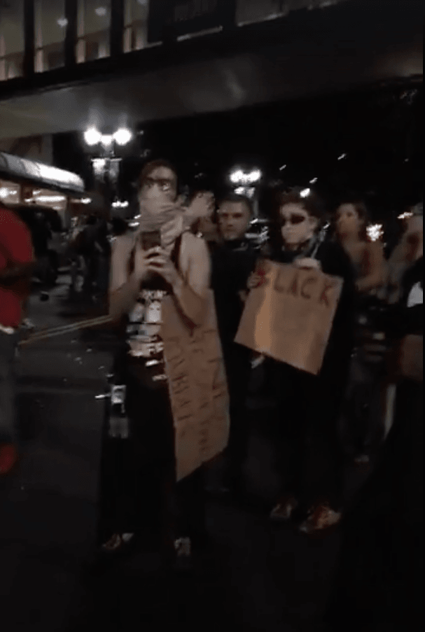 Senior Colin Nollet, senior Dan Hitesman and senior Eva Cosgrove hold posters at the rally in downtown Charlotte on Sept. 21. Courtesy of Najha Zigbi-Johnson