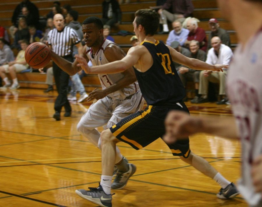 Guilford College guard/forward Dominique Henderson drives past Emory & Henry College guard John Shelor in the second half of the Quakers game against the Wasps in Ragan-Brown Field House on Wednesday, Feb. 15, 2017. Senior Henderson scored five points and had five rebounds for the Quakers during Senior Night. The Wasps beat the Quakers, 65-60. 