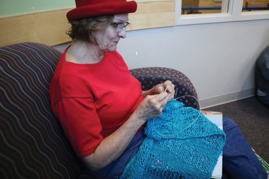 While waiting for students to arrive at her knitting class, Carol Phillips, a resident of Jamestown and knitter for 50 years, works on her latest creation, a lace blue shawl, at the Hemphill Branch Library. Photo by Praveena Somasundaram/The Guilfordian