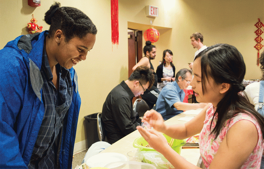Xinxin Zhou teaches Mikayla Jones how to make dumplings during the Chinese New Year celebration.// Photo by Christopher Perez/The Guilfordian