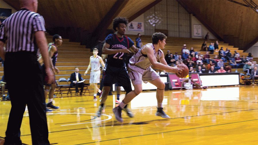 Junior Carson Long defends the ball seconds before scoring against Shenandoah University. Long added his ninth double-double with 13 points and 15 rebounds. // Photo by Fernando Jiménez/The Guilfordian