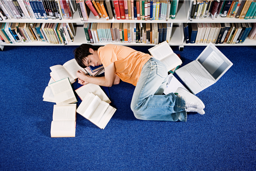 A student taking a nap to exercise self care and deal with the stress of school work. 