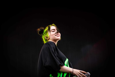 Billie Eilish smiling towards the crowd at one of her live concerts