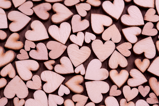 A collection of painted pink wooden hearts, one of the most common symbols of Valentine’s Day.